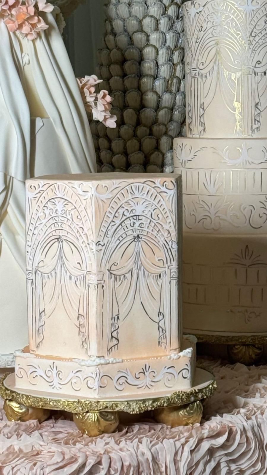 Sculpted ivory engagement cake with architectural arches, created in Qatar for a celebration in Riyadh.